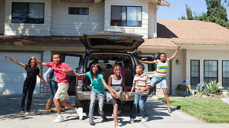 Un nutrido grupo de niños juegan felices en la entrada de una vivienda